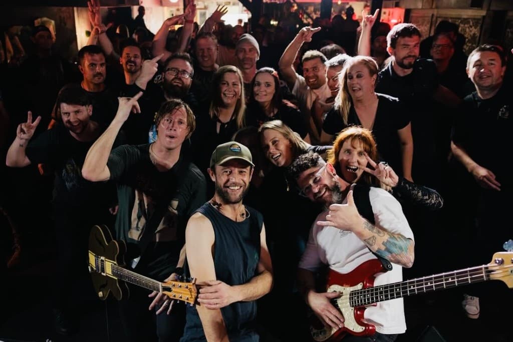 Dumpweed band posing with an enthusiastic crowd after a live show