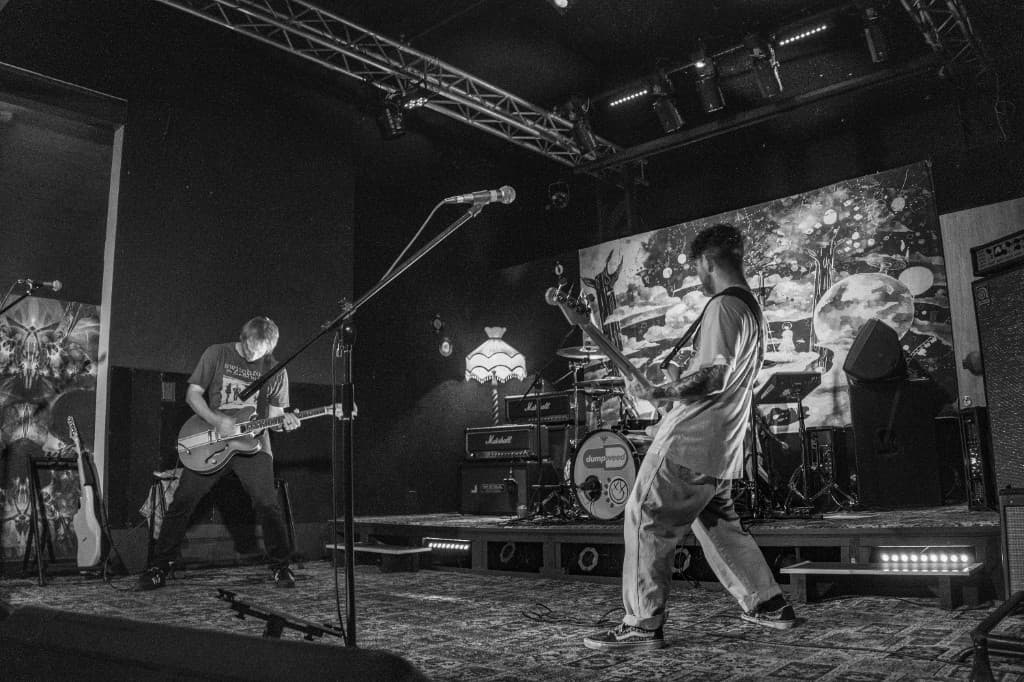 Black and white photo of Dumpweed performing on stage